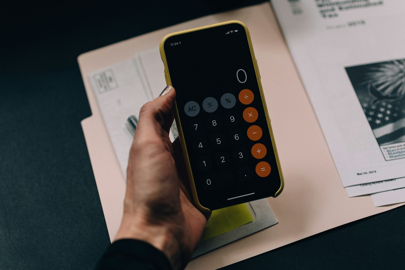 Pessoa organizando despesas e orçamento com caderno e calculadora