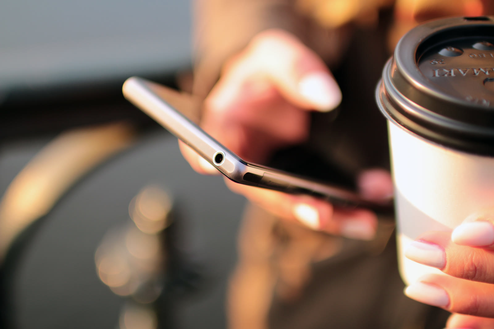 Pessoa usando smartphone em um ambiente de trabalho, representando atendimento e vendas no WhatsApp
